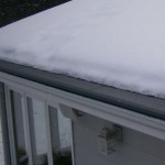 View of a snow covered roof, with the gutters clear of ice and snow
