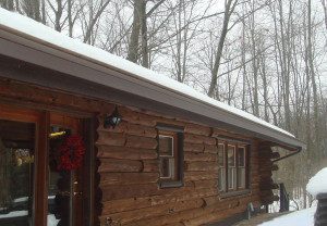 a log home with seamless heated gutters in the winter