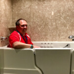 A Rainbow Seamless employee sitting in a Jacuzzi walk in tub