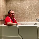 A Rainbow Seamless employee sitting in a Jacuzzi walk in tub