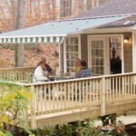Motorized Awning over an outdoor deck seating area with four people seated around a table