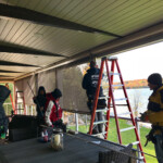Rainbow Seamless Employees Installing Motorized Screens on an Under Deck Patio